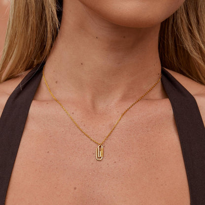 Collana con pendente a forma di graffetta in cristallo dorato